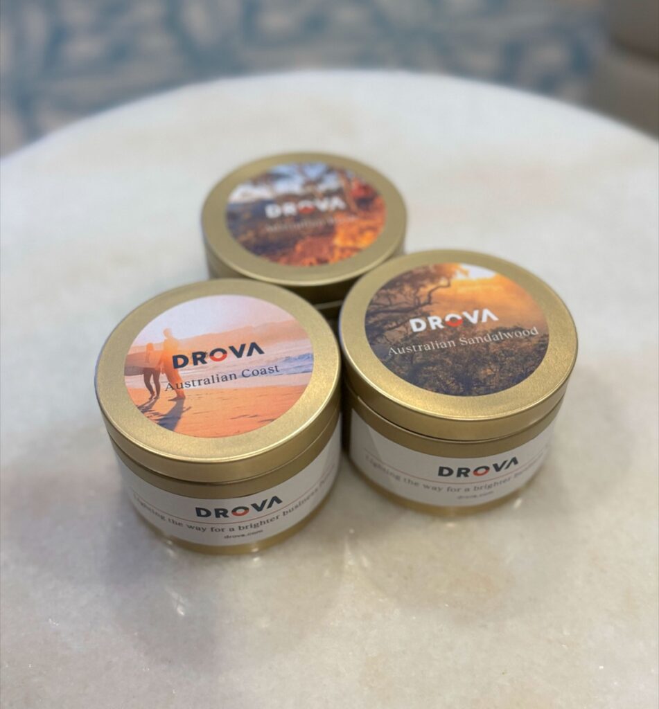 Close up of hand poured soy candle tins with kraft lids drying before Drova branded labels are applied